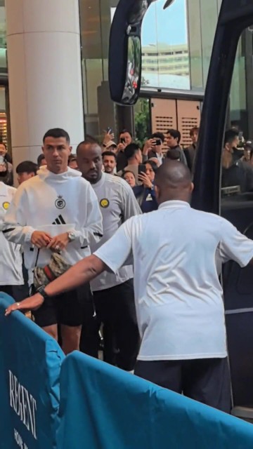 C罗上大巴前朝球迷比大拇指，手里还拿了一个葡萄牙球衣的Labubu